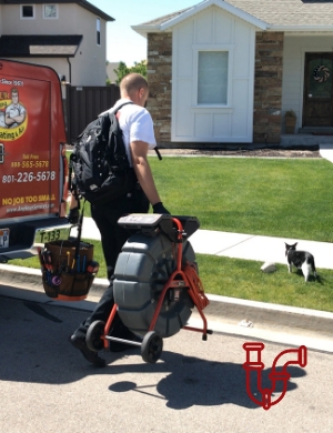 Plumber carrying drain clearing equipment from truck into house